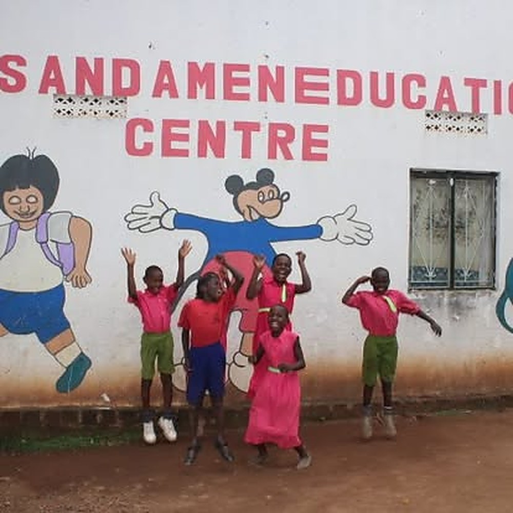 YAEC pupils jumping for joy in front of the school mural