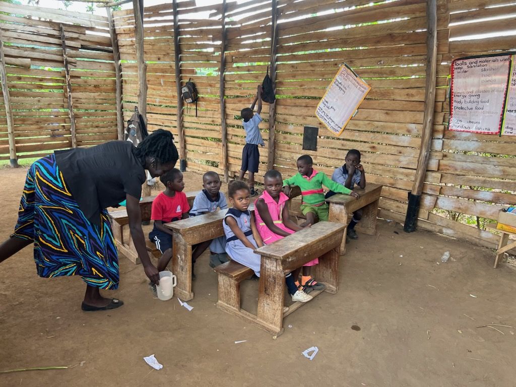 Young pupils and their teacher in the timber classroom