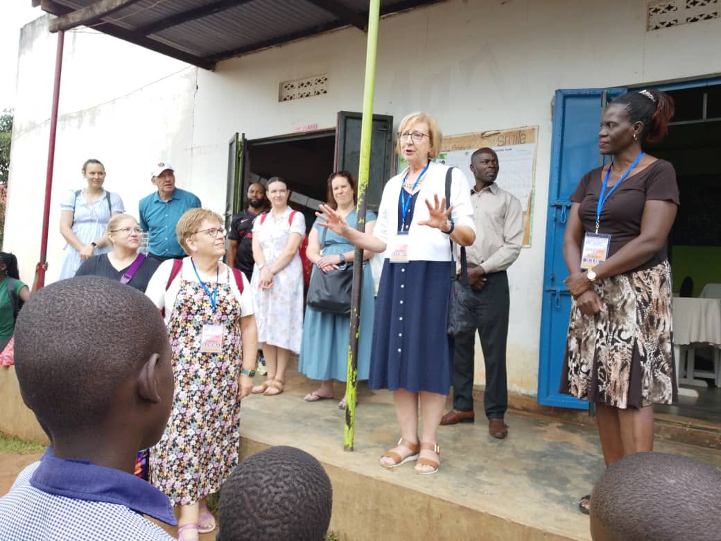 A volunteer greets the pupils
